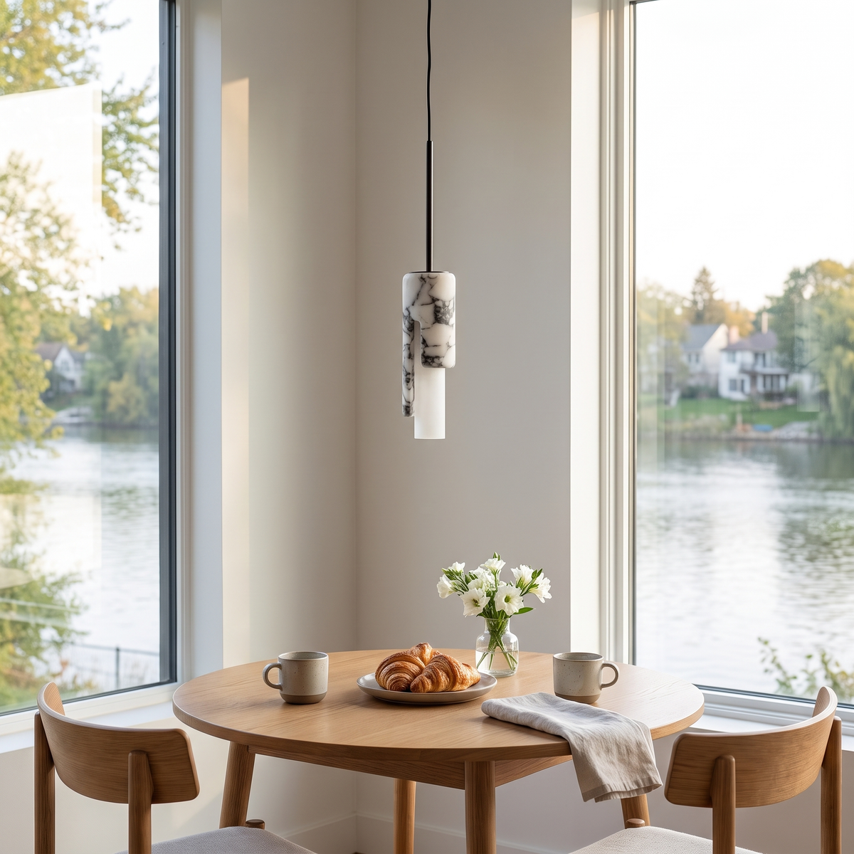 Marble cylinder pendant light switched off over a small dining table in daylight